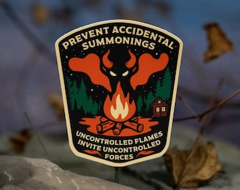 May include: A sticker with a black border and a design featuring a campfire, a forest, and a red demon-like figure. The text reads "PREVENT ACCIDENTAL SUMMONINGS" and "UNCONTROLLED FLAMES INVITE UNCONTROLLED FORCES".
