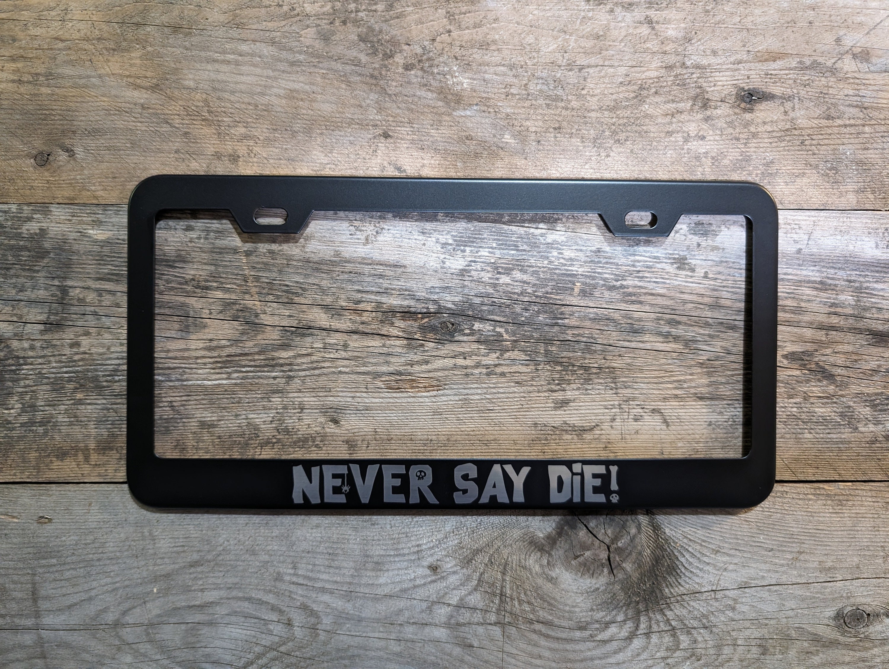 The Goonies 'Never Say Die!' Black License Plate Frame – Car Tag Holder – Novelty Gift
