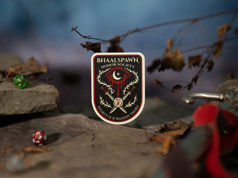 Puede incluir: Una pegatina rectangular con fondo negro y borde rojo. La pegatina presenta el texto "BHAALSPAWN HONOR SOCIETY" y una ilustraci&oacute;n de un ojo, espadas y un dado. Tambi&eacute;n est&aacute; presente el texto "LEGACY IS A BLOODY THING". Dos dados en el fondo.