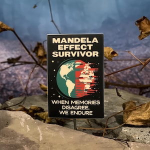 May include: A black rectangular pin with the words "MANDELA EFFECT SURVIVOR" in white. The pin features a graphic of the Earth, split between green and red, with the text "WHEN MEMORIES DISAGREE, WE ENDURE."