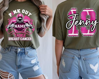 May include: Olive green t-shirt with a pink football-themed graphic supporting breast cancer awareness. The front features a football player and the words "PINK OUT" and "TACKLE BREAST CANCER". The back displays the number "19" and the name "Jenny" in pink.