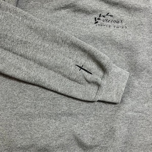 Op de afbeelding: Een grijze gem&ecirc;leerde sweatshirt met de in zwart geborduurde tekst "vicious little thing" op de borst. Een zwart zwaard is geborduurd op de linkermouw. De sweatshirt heeft een ronde hals en lange mouwen.