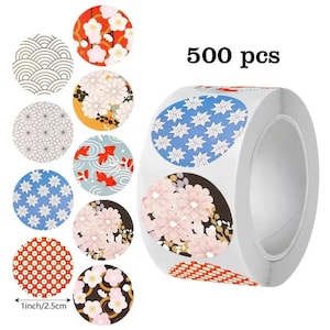 以下が含まれることがあります： 様々な日本のデザインが施された装飾ステッカーのロール。ステッカーには、花柄、幾何学模様、鯉の模様があります。ロールには500枚入っています。各ステッカーの直径は2.5cmです。