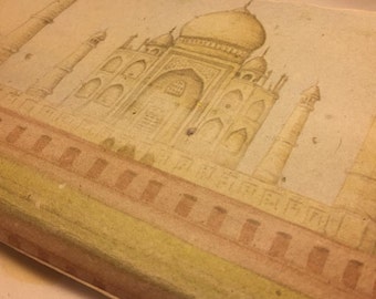 May include: A watercolour painting of the Taj Mahal, a white marble mausoleum in Agra, India. The painting is done in shades of beige and brown, with a light background.