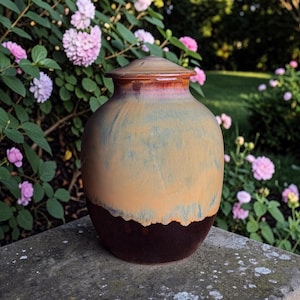 Peut inclure: Une tasse en céramique blanche avec une anse noire et le texte "But First, Coffee" en noir, dans une police manuscrite. La tasse est posée sur une surface blanche.