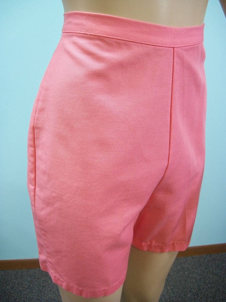 May include: A pair of coral pink shorts with a high waist and a straight leg.
