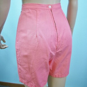 May include: A pair of high-waisted pink shorts with a zipper closure in the back.