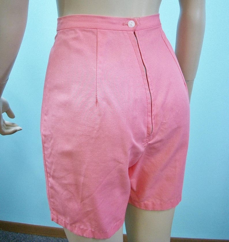 May include: A pair of high-waisted pink shorts with a zipper closure in the back.