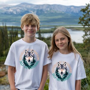 May include: Two children wearing white t-shirts with a wolf graphic and the text "Republic of Sovereigns Self-Determining".