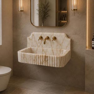 Luxury Calacatta Gold marble wall mounted bathroom sink with fluted front and backsplash, handcrafted natural stone vanity basin in a modern bathroom.
