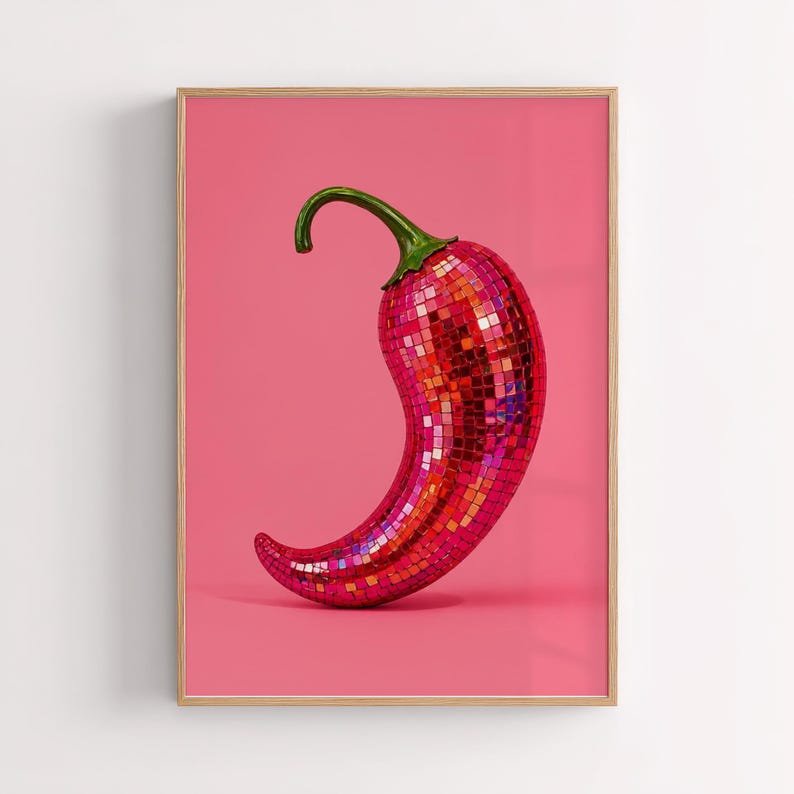 May include: A framed wall art print featuring a chili pepper covered in reflective, multi-colored mosaic mirror tiles. The chili pepper has a green stem and is set against a solid, vibrant pink background, creating a high-contrast visual display.