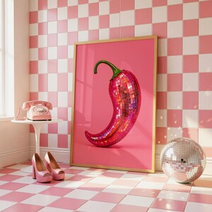 May include: A framed rectangular wall art print featuring a vibrant pink chili pepper covered in reflective, multi-colored disco ball mirror tiles. The chili pepper has a green stem and is set against a solid, bright pink background.