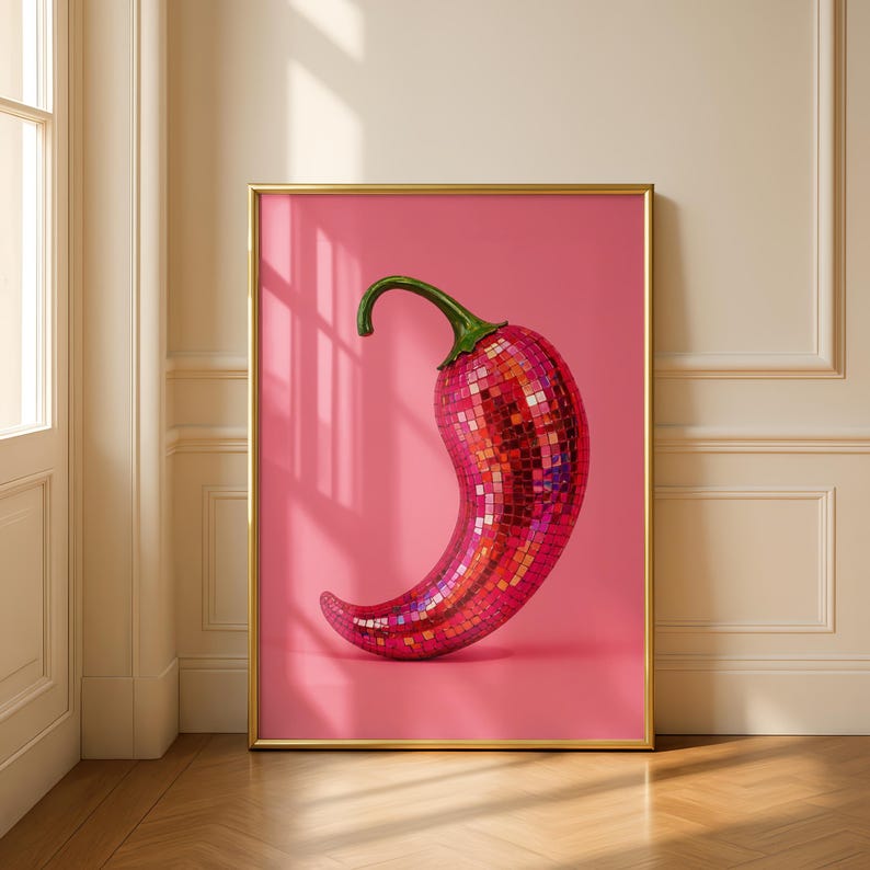 May include: A framed wall art print featuring a chili pepper covered in reflective pink and red mosaic mirror tiles. The pepper has a green stem and is set against a solid pink background, encased in a thin gold frame for a clean display.