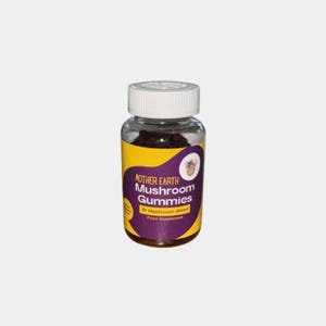 May include: A clear plastic bottle with a white lid containing dark brown mushroom gummies. The label is yellow with purple text that reads "Mother Earth Mushroom Gummies 10 Mushroom Blend Food Supplement".