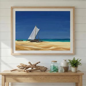 May include: A framed painting depicting a sailboat on a beach with a blue sky. The artwork shows a white-sailed boat, a small boat, and a turquoise sea. The painting is displayed above a wooden table with decorative items.