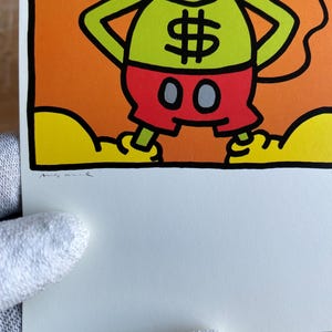 K&ouml;nnte beinhalten: Eine gr&uuml;ne Comicfigur mit einem blauen Irokesenschnitt, die rote Shorts mit einem Dollarzeichen auf der Vorderseite und schwarzen und grauen Kreisen an den Seiten tr&auml;gt. Die Figur steht auf einer gelben Wolke mit schwarzem Umriss.