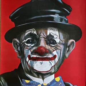 May include: A vintage poster featuring a clown with a black hat, white makeup, and a blue bow tie with yellow polka dots. The clown has a sad expression and is set against a red background.