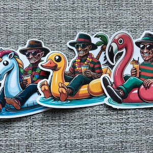 May include: Three horror movie characters are riding inflatable pool floats. One is riding a unicorn, one is riding a yellow duck, and one is riding a pink flamingo. All three are wearing Hawaiian shirts and sunglasses.