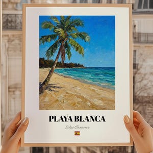 May include: A framed art print featuring a beach scene. The painting shows a palm tree on a sandy beach with turquoise water and a bright blue sky. The words "PLAYA BLANCA" are printed at the bottom, with "Islas Canarias" below.