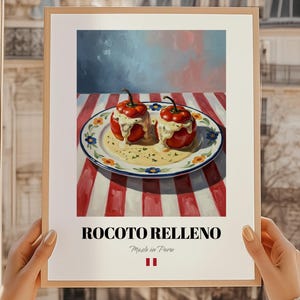 Peut inclure: Une affiche encadrée représentant Rocoto Relleno, un plat péruvien. Deux poivrons rouges farcis d'une sauce crémeuse sont servis sur une assiette décorée. L'arrière-plan comprend une nappe à rayures rouges et blanches et un ciel bleu et gris. Le texte "ROCOTO RELLENO" est affiché.