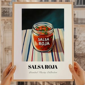 Può includere: Una stampa incorniciata con un barattolo di salsa rossa con la scritta "SALSA ROJA" in bianco. Il barattolo è posto su una tovaglia a righe. Sotto il barattolo, le parole "SALSA ROJA" sono visualizzate in grassetto, con "Essential Flavors Collection" sotto.