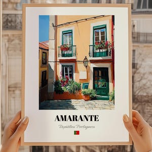 May include: A framed print featuring a colorful illustration of a building in Amarante, Portugal. The building has a yellow facade, green doors and window frames, and balconies with flowers. The print includes the text "AMARANTE" and "República Portuguesa".