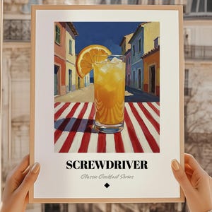 Peut inclure: Impression d'art encadrée d'un cocktail Screwdriver. L'œuvre représente un verre de la boisson orange avec de la glace et une tranche d'orange, sur fond de bâtiments colorés. Le texte "SCREWDRIVER" est en bas.