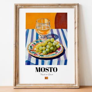 May include: A painting of a glass of white wine and a plate of green grapes on a blue and white striped tablecloth. The painting is titled "Mosto" and says "Made in Spain" with a Spanish flag.