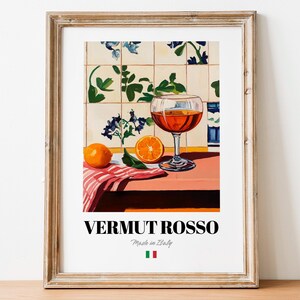 Può includere: Un dipinto che raffigura un bicchiere di vermut rosso, due arance e un panno a righe rosse e bianche su un tavolo. Lo sfondo è una parete piastrellata con fiori blu e bianchi. Il testo "Vermut Rosso Made in Italy" è stampato sotto l'immagine.