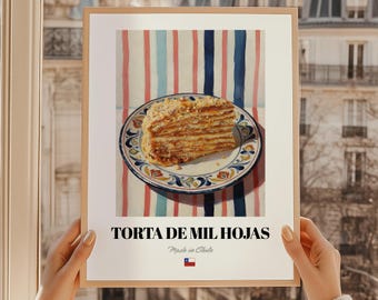 May include: A framed print featuring a slice of Torta de Mil Hojas on a decorative plate. The cake sits on a striped background of red, blue, and white. The text "TORTA DE MIL HOJAS" is displayed below the image, with "Made in Chile" and a Chilean flag.