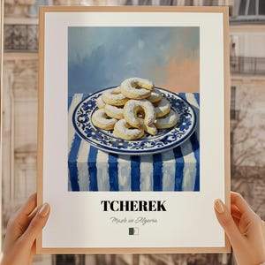 Könnte beinhalten: Ein gerahmter Druck mit einem Stillleben von Tcherak-Keksen auf einem blau-weißen Teller. Der Teller steht auf einer blau-weiß gestreiften Tischdecke. Der Druck enthält den Text "TCHERAK Made in Algeria".