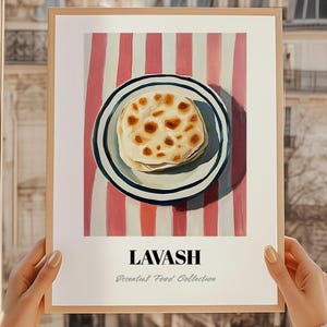 Peut inclure: Impression d'art encadrée représentant du pain lavash sur une assiette à bordure bleue et blanche, sur un fond à rayures rouges et blanches. Le mot "LAVASH" est imprimé en noir gras, avec "Essential Food Collection" en dessous.