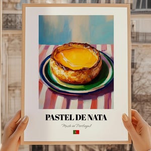 Puede incluir: Impresión enmarcada de un Pastel de Nata, una tarta de crema portuguesa, sobre un plato. La impresión incluye el texto "PASTEL DE NATA" y "Made in Portugal" con la bandera portuguesa.