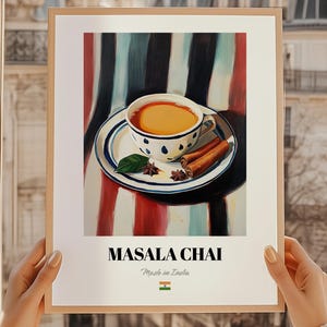 May include: A framed print featuring a cup of masala chai on a saucer with cinnamon sticks and star anise. The cup has a white base with blue polka dots. The text "MASALA CHAI" is displayed below the image, with "Made in India" underneath.