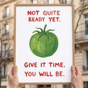 May include: A framed art print featuring a green tomato illustration. The text in red reads "NOT QUITE READY YET. GIVE IT TIME. YOU WILL BE."