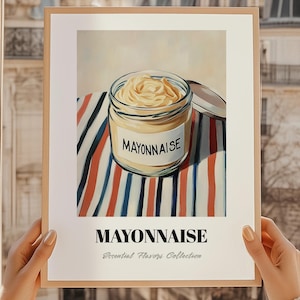 Może przedstawiać: Oprawiony wydruk przedstawiający słoik majonezu na pasiastym materiale w kolorach czerwonym, białym i niebieskim. Etykieta na słoiku głosi "MAYONNAISE". Wydruk zawiera również tekst "MAYONNAISE" i "Essential Flavors Collection".