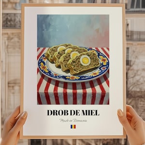 May include: A framed print featuring a still life of sliced Romanian Drobul de Miel, a savory dish with eggs, on a decorative plate. The print includes the text "DROB DE MIEL" and "Made in Romania" with the Romanian flag.