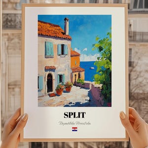 Könnte beinhalten: Ein gerahmter Kunstdruck einer Küstenlandschaft in Split, Kroatien. Das Gemälde zeigt Gebäude mit orangefarbenen Ziegeldächern, blauen Fensterläden und Topfpflanzen. Der Text "SPLIT" und "Republika Hrvatska" stehen darunter, zusammen mit der kroatischen Flagge.