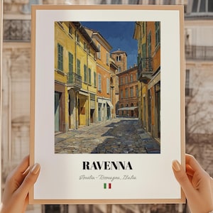 May include: A framed print of a street scene in Ravenna, Italy. The artwork depicts colorful buildings with yellow, orange, and green hues, with a cobblestone street. The print includes the text "RAVENNA" and the Italian flag.