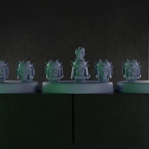 Op de afbeelding: Een set van zeven grijze miniatuur soldatenhoofden, elk voorzien van een helm met stekels. De hoofden zijn in een rij op drie afzonderlijke ronde voetstukken geplaatst, waarbij het middelste hoofd een opvallende pluim op de helm heeft.
