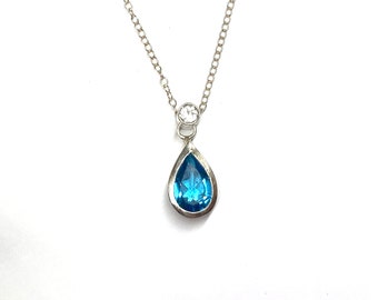 Pear shaped blue Topaz necklace pendant with round white faceted Topaz set bail in Sterling Silver with lobster clasp Sterling Silver chain