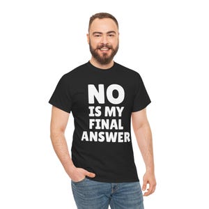 Op de afbeelding: Zwart T-shirt met de tekst "NO IS MY FINAL ANSWER" in grote, witte, vette letters. Het T-shirt wordt gedragen door een persoon met een baard en een blauwe spijkerbroek. Het T-shirt is een casual item.