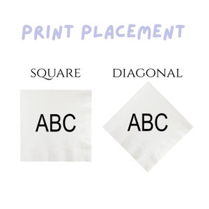 May include: Two white napkins with the letters "ABC" printed on them. The napkin on the left is square and the napkin on the right is folded diagonally.