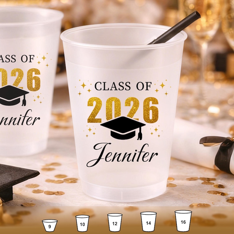 May include: A frosted plastic party cup featuring the black text "CLASS OF" above the gold glitter numbers "2026" and a black graduation cap icon. The name "Jennifer" is printed in black script below. A black straw is inside the cup.