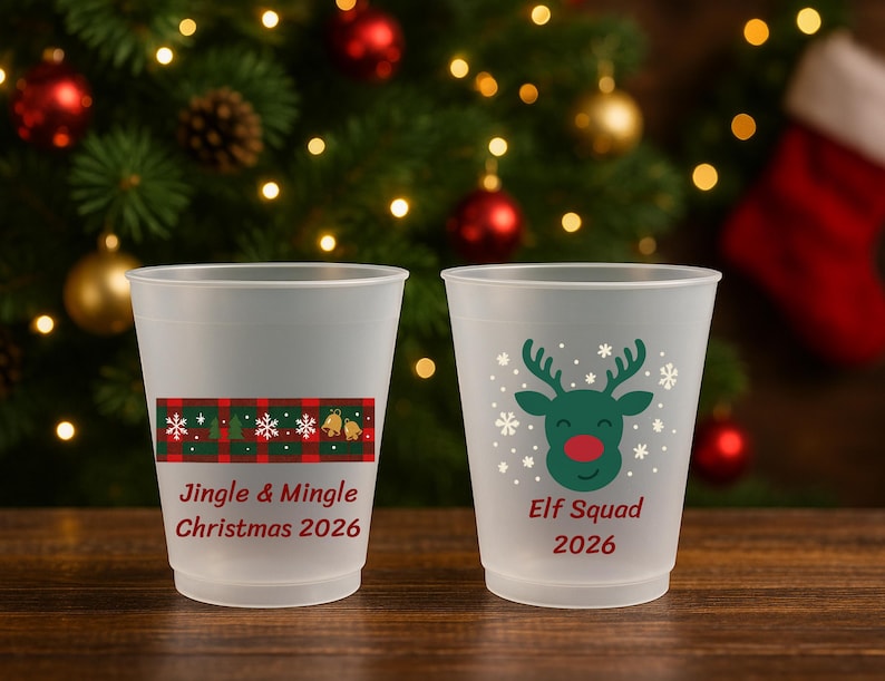 May include: Two frosted plastic cups featuring Christmas designs. One cup displays a red and green plaid pattern with the text Jingle & Mingle Christmas 2026. The other cup features a green reindeer graphic with the text Elf Squad 2026.