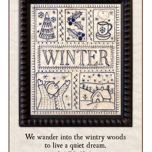 Könnte beinhalten: Ein gerahmter Kreuzstich-Sampler mit Wintermotiv. Der Sampler zeigt einen Schneemann, eine Winterszene, einen Weihnachtsbaum und eine Tasse heiße Schokolade. Der Text "WINTER" ist in der Mitte des Samplers gestickt. Das Zitat "We wander into the wintry woods to live a quiet dream." ist unter dem Sampler gedruckt. Der Name der Künstlerin, "Kathy Schmitz", ist unter dem Zitat gedruckt.