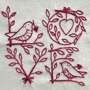 May include: Embroidered design of the word "love" with two birds and hearts. The design is done in a dark red thread on a white fabric.