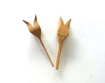 May include: Two wooden tulip-shaped ornaments, one with a closed bud and the other with an open bud.