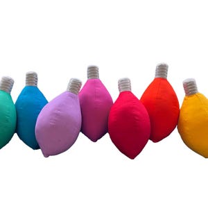 May include: Ten plush lightbulb ornaments in various colors, including yellow, green, blue, purple, pink, red, orange, and white.