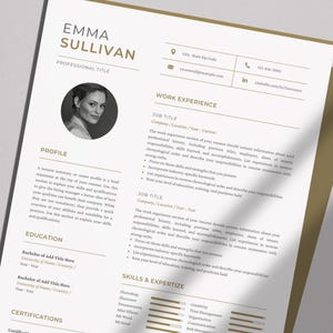 以下が含まれることがあります： 「EMMA SULLIVAN」という名前が金色の文字で書かれた、プロフェッショナルな履歴書のテンプレート。履歴書には、プロフィール、職務経験、学歴、スキルなどのセクションが含まれています。顔写真は円形のフレームに入っています。書類は白い背景にあります。